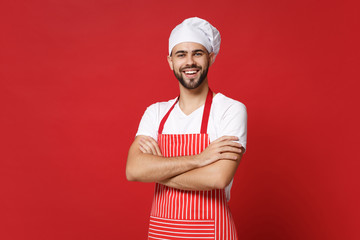 Smiling young bearded male chef cook or baker man in striped apron white t-shirt toque chefs hat...