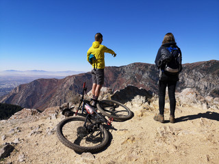 Fototapeta premium Asian biker man pointing and caucasian hiker woman enjoying the view from Sardine Peak Trailhead
