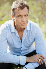Obraz premium 40-50 years old business man in a blue suit posing outdoor