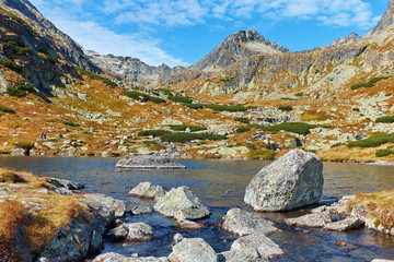 Mountains of the High Tatras National Park and the autumn Pleso nad Skokom lake with stones in the estuary of the skok stream in Slovakia - obrazy, fototapety, plakaty