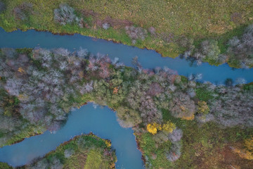 Aerial view with a drone. Winding river with autumn forest, top view