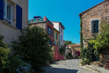 The picturesque street of a seaside French town planted with flowers and with bright, colorful houses