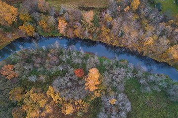 Aerial view with a drone. Winding river with autumn forest, top view