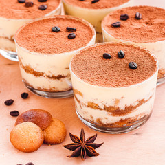 Tiramisu in the glass decorated whith mint on the wooden background