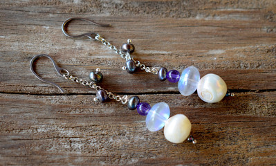 Close up of a pair earrings on a wooden surface