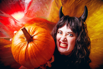 Gruselige frau mit Halloween Kürbis  auf einem dunkelem Hintergrund, Halloween Party