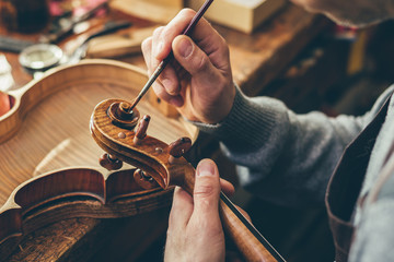 Luthier repair violin in his workshop - obrazy, fototapety, plakaty