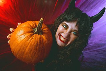 Gruselige frau mit Halloween Kürbis  auf einem dunkelem Hintergrund, Halloween Party