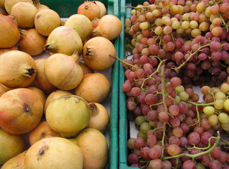 Fall farmers market display of white pomegranates, red flame grapes