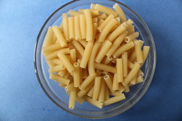 Penne pasta in a plate on a blue background