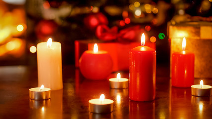 Obraz na płótnie Canvas Closeup photo of lots of candles on wooden table decorated for Christmas eve