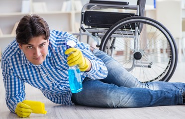Disabled man on wheelchair cleaning home