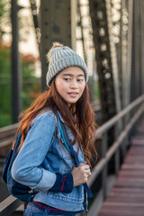 Asian tourist woman with backpack walking on black iron bridge, lifestyle concept.