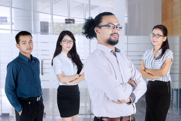 Business people stands with folded arms in office