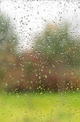 Raindrops on a window pane. The view from the room. Autumn weather concept.
