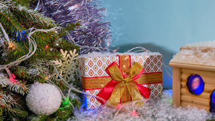 Gift box covered with snow under a fir tree. New year gifts 2020. Christmas gift