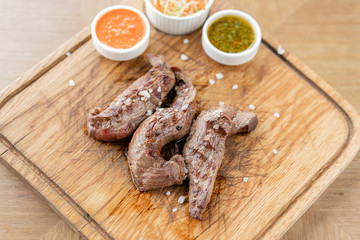 Lamb tenderloin with Pickled cabbage and two sauces. Serving on a wooden Board. Barbecue restaurant menu, a series of photos of different meats.
