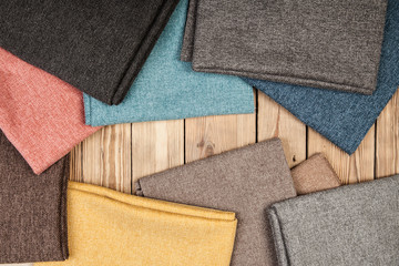 Arrangement from various colorful textile materials on wooden background