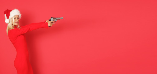 Sexy Santa helper with gun isolated on red background.