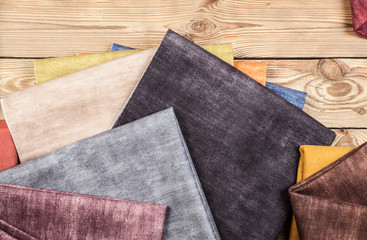 Arrangement from various colorful textile materials on wooden background
