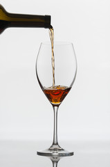 Amber wine is poured into a glass.