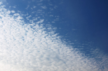 Summer background with white flying clouds on blue sky. Romantic natural heaven backdrop. 