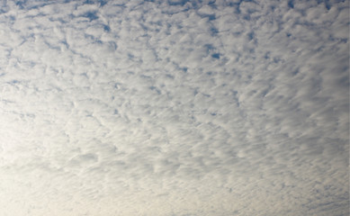 Summer background with white flying clouds on blue sky. Romantic natural heaven backdrop. 