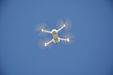 low angle view of drone in the sky. Drone from below with blue sky in the background
