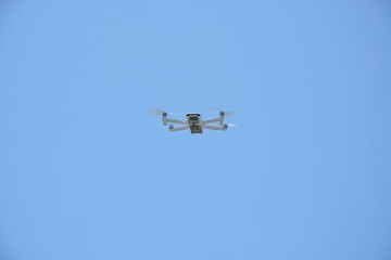 low angle view of drone in the sky. Drone from below with blue sky in the background