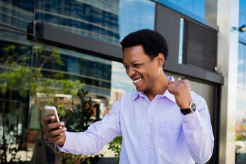 Businessman excited  looking at cell phone.
