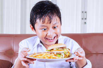 Little boy have a great desire to eat junk foods