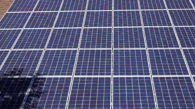 Slow panning shot of many solar panals on roof.Renewable technology.