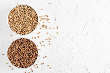 two plates with green and ordinary buckwheat top view white background