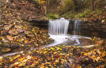 Fototapeta na wymiar Waterfall green forest river stream landscape. Autumn time.