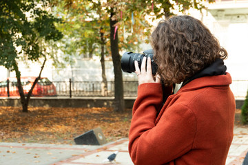 Girl photographer with red hair with a camera