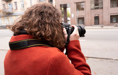 Girl photographer with red hair with a camera