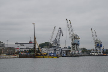 Fototapeta na wymiar Gdansk, Poland - September 2019: View of the Gdansk Shipyard, shipyard. Gantry crane and moored ship. The tanker is moored in the port.