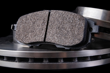 Steel brake discs and brake pads for a passenger car. New spare parts for car repairs.