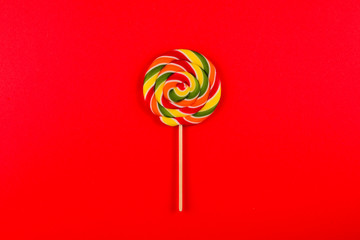 Colorful candy on a red  background. Lollipop. Top view. Copy space.