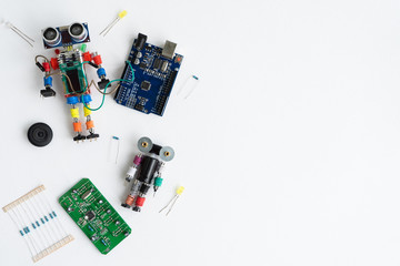 STEM school concept. A metal robot and an electronic board that can be programmed. Robotics and electronics. DIY robotics. STEM education for kids. Flat lay. Free space for text. White background.