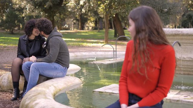 Love Triangle. young sad woman looking at ex boyfriend kissing other woman