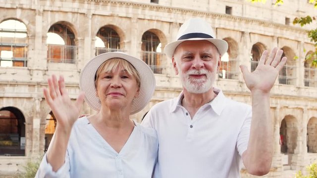 Portrait of family enjoy gastronomic tour in Rome. Silly pensioners make tasty delicious gesture with hands. Concept of yummy italian cuisine. Senior couple have great time near Colosseum in Italy