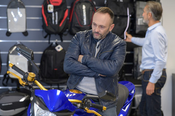 Fototapeta na wymiar man interested in buying a motorbike in store