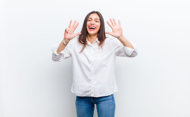 young pretty woman smiling and looking friendly, showing number nine or ninth with hand forward,...