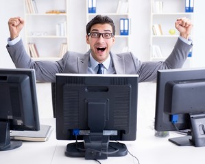 Businessman sitting in front of many screens