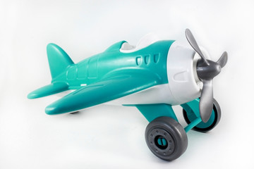 toy, plastic airplane with a propeller, without a pilot on a white background, turquoise brush, side view