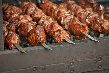 Barbecue fries in the coals. Meat and beef at the field kitchen festival.