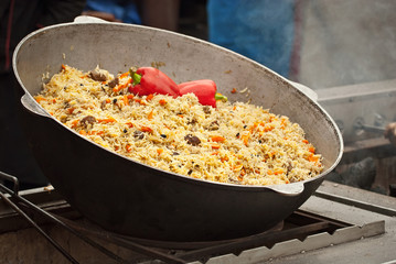 Large cauldron floating at the city fair. Red peppers, garlic, meat and incas in porridge.