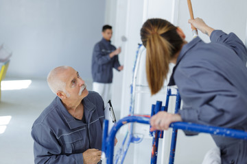 painters painting the walls white in house
