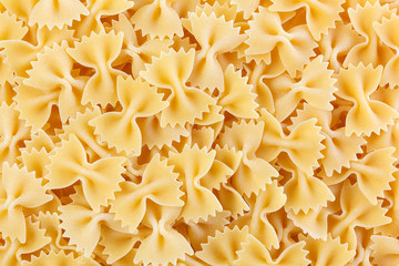 Variety of types and shapes of Italian pasta. Dry pasta background. A portion of Farfalle bows...